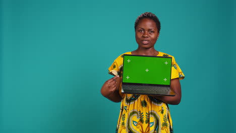 Natural-smiling-woman-posing-with-a-green-screen-on-laptop