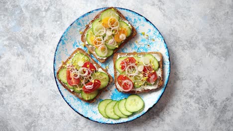 Teller-Mit-Toasts-Mit-Gurkentomaten-Und-Zerbröckeltem-Feta-Und-Rettichsprossen