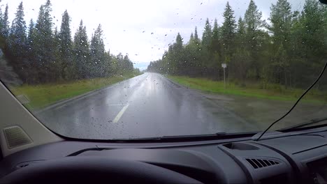 view from the car in the rain driving on wet roads. driving a car on a road in norway