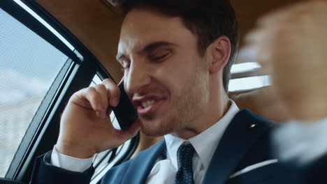 Portrait-of-happy-business-man-getting-good-news-on-phone-in-business-car.