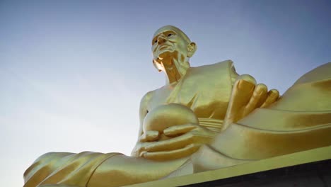 4k bottom-up view of a golden statue of a buddhist monk luang pu thuat