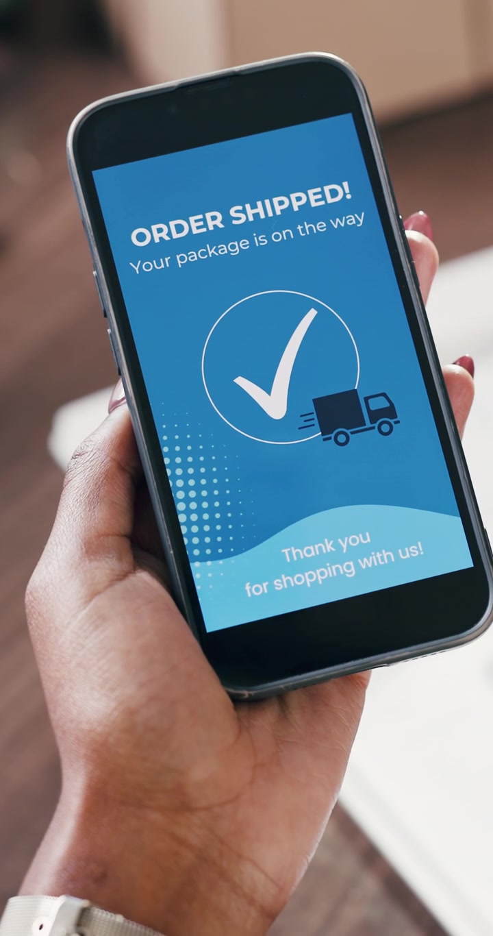 Person Holding Smartphone Displaying Order Shipped Notification