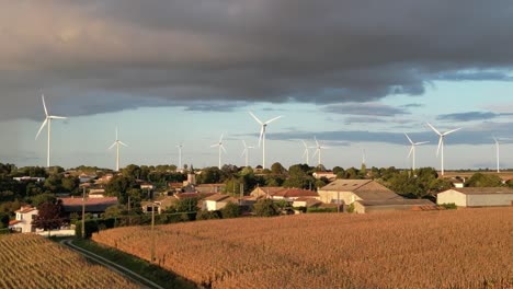 Windkraftanlagen-Hinter-Einem-Französischen-Dorf-Mit-Einer-Grauen,-Stürmischen-Wolke-Darüber