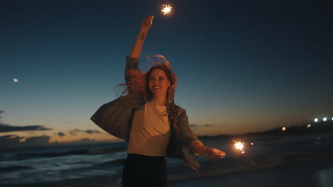 mejores amigos bailando con bengalas en la playa por la noche chicas adolescentes celebrando la víspera de año nuevo divirtiéndose bailando con fuegos artificiales de bengala junto al mar