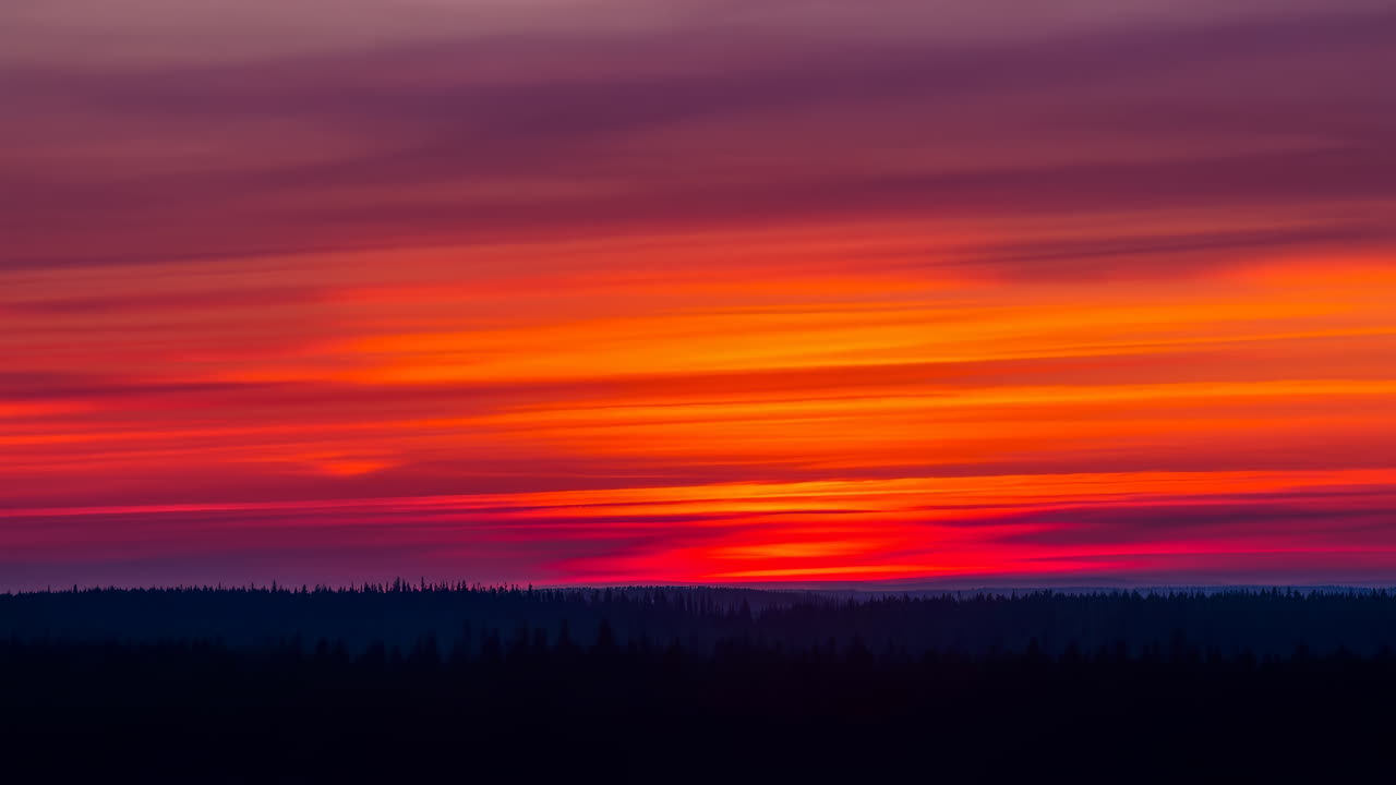 Vibrant Orange Sunset Over Horizon, Layered Magenta And Purple Clouds Streaking Across Sky Above Dark