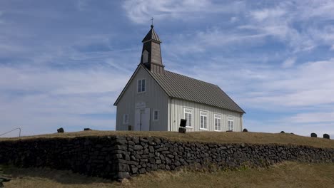 time lapse clouds behind a pretty church, strandakirkja, in iceland