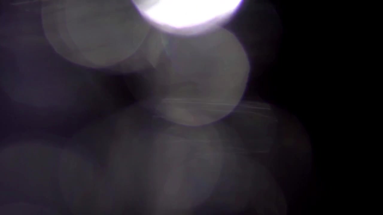 Fughe di luce astratte e sovrapposizioni bokeh su sfondo nero