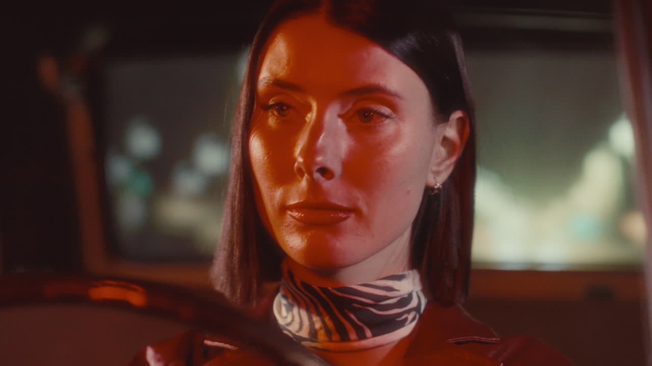 Young Pretty Woman with Red Lipstick Driving Car at Night