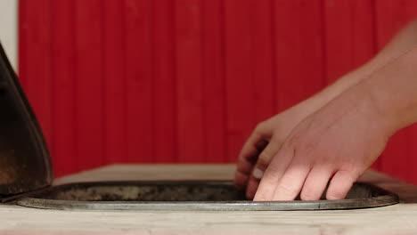 unrecognizable man opens the lide on the bbq or barbecue grill in sweden on a warm summer day