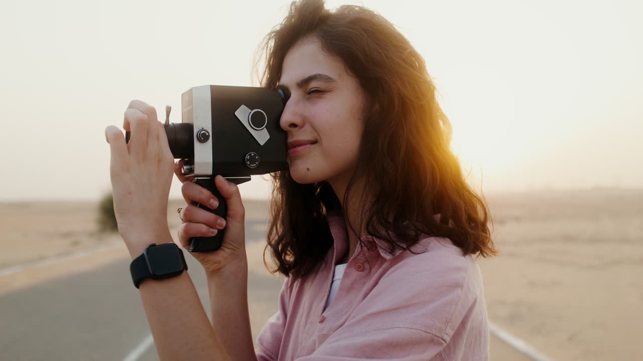 mujer filmando en un paisaje desértico