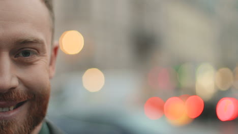 half face portrait of happy caucasian businessman with a beard smiling to the camera cheerfully in the street in autumn