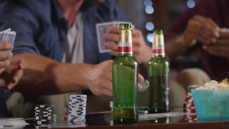 male friends playing cards at home, mid section close up, shot on r3d