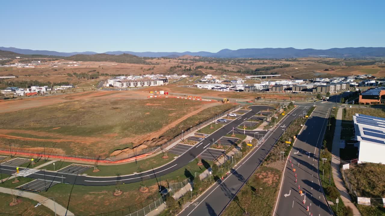 An aerial perspective of an intersection under construction in Canberra, featuring visible roadwork signs and ongoing development activities.