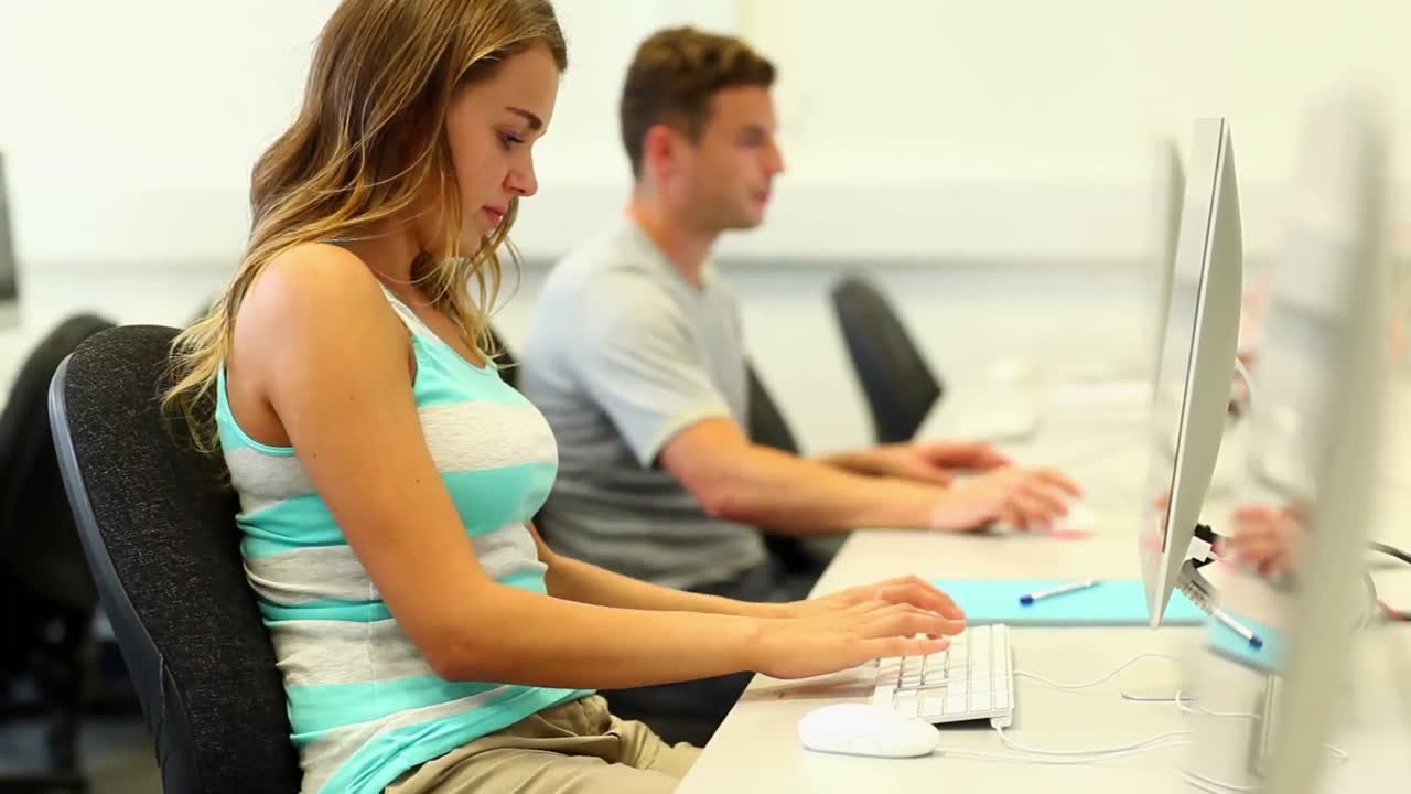 estudiantes enfocados trabajando en la sala de computadoras