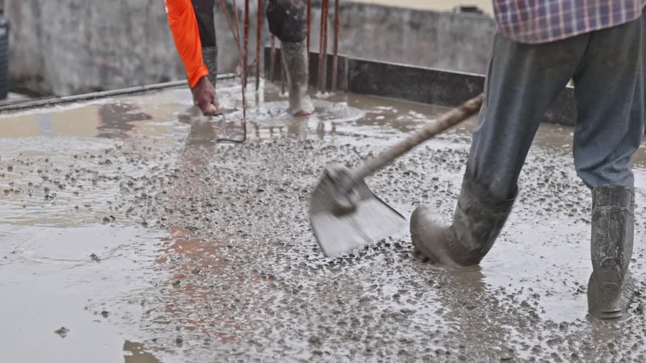 Workers Leveling Fresh Concrete with Shovel tool and checking depth of slab at construction site. day time, slight pan shot, 4k