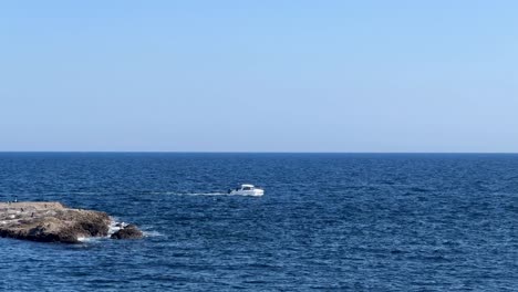 boat cruising near a rocky coast under clear blue skies