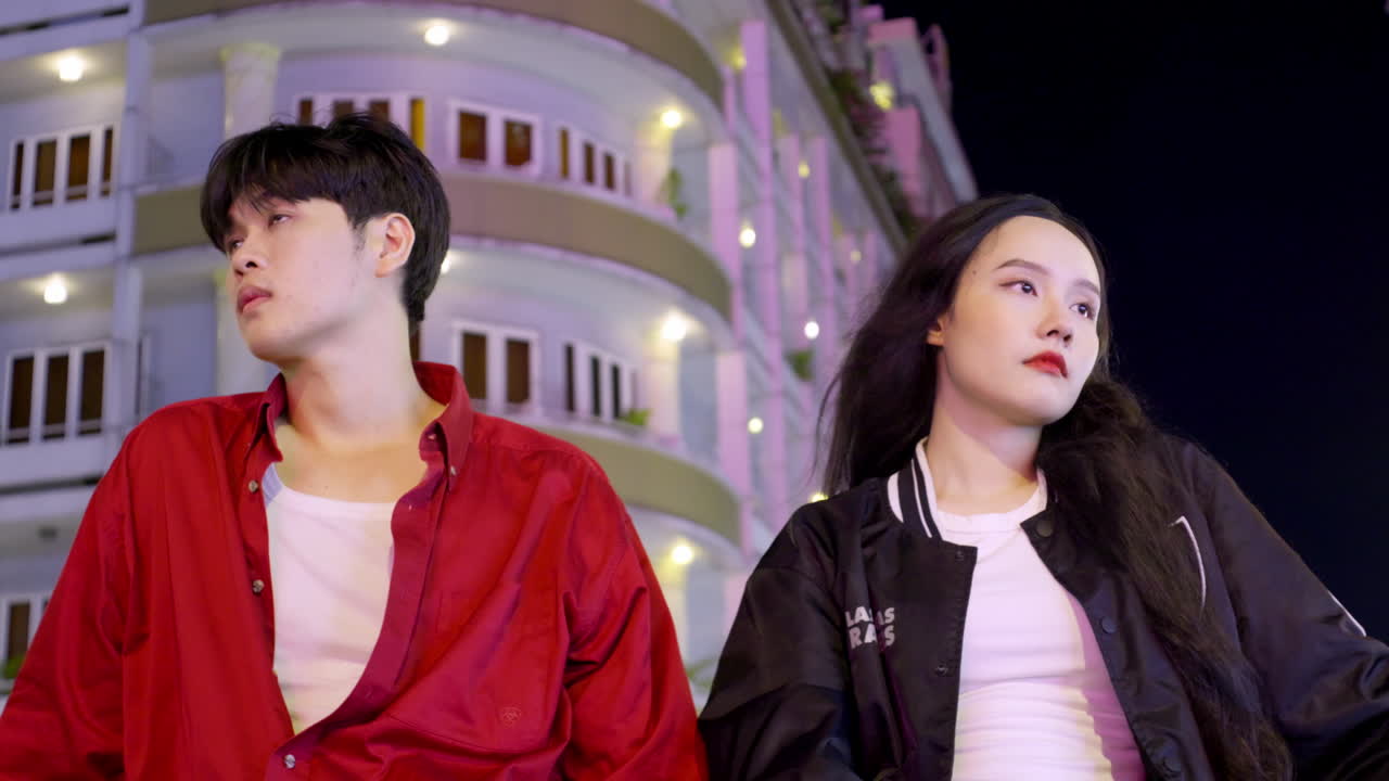 슬프고 화가 난 아시아 연인 부부는 밤에 도시 배경으로 여행하며, 깨진 마음의 관계 개념을 가지고 있습니다.