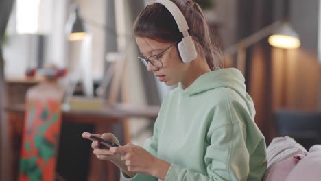 teenage girl playing mobile game on smartphone