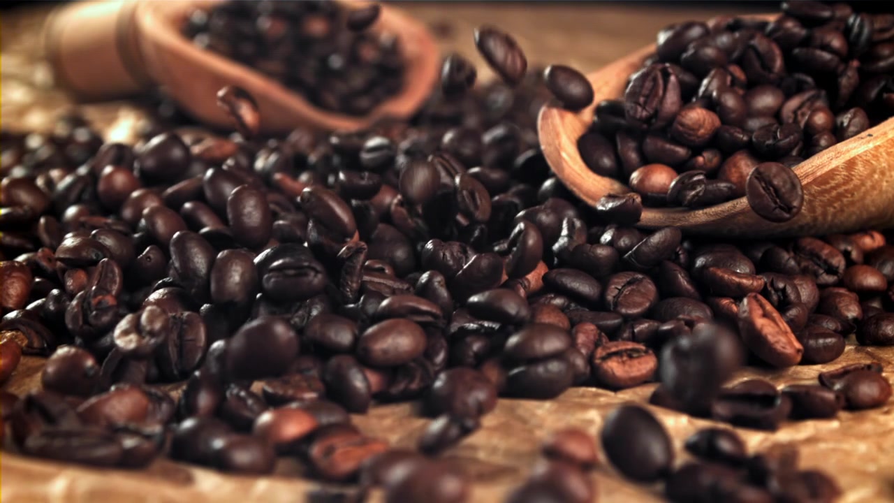 Fagioli di caffè arrostiti che cadono al rallentatore