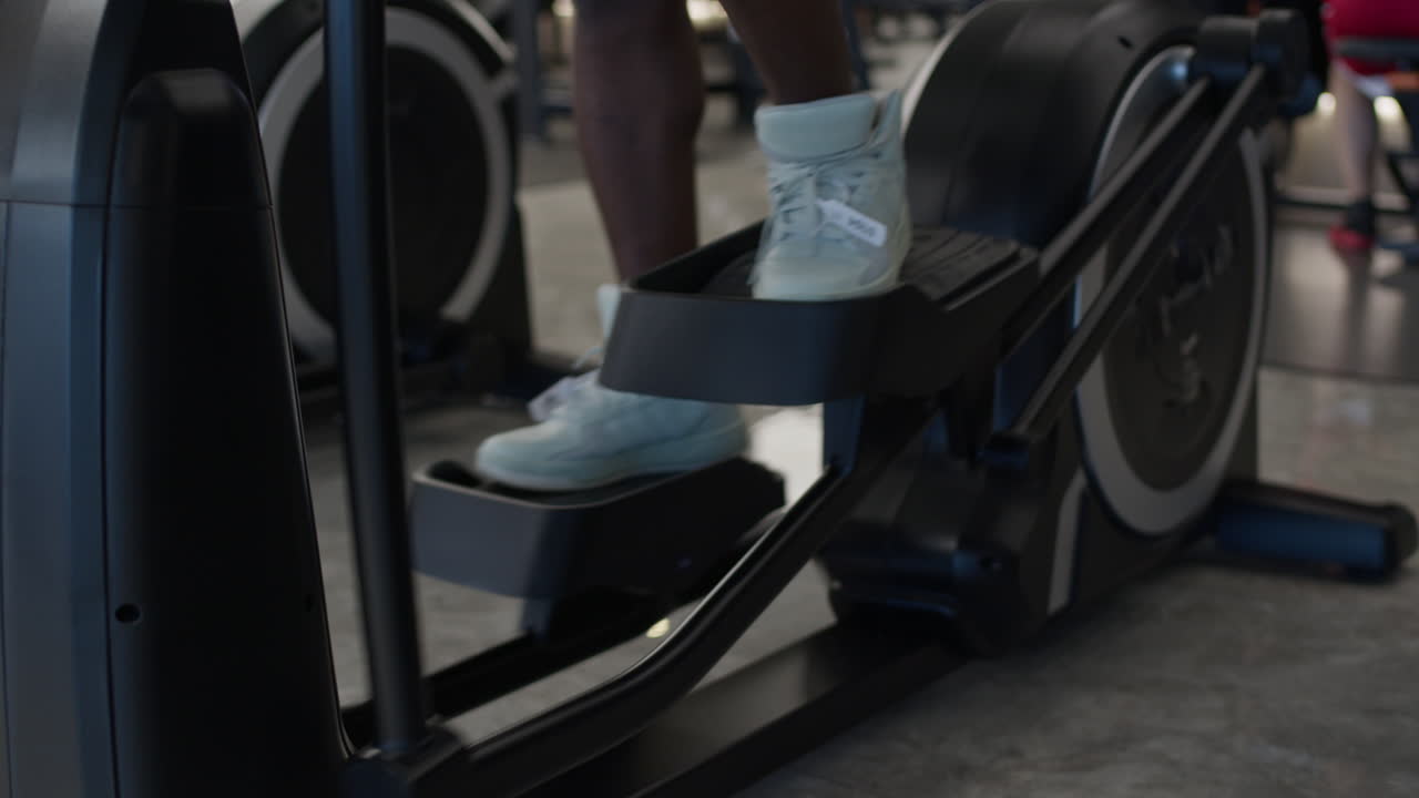 Donna che si allena sull'ellittica in palestra