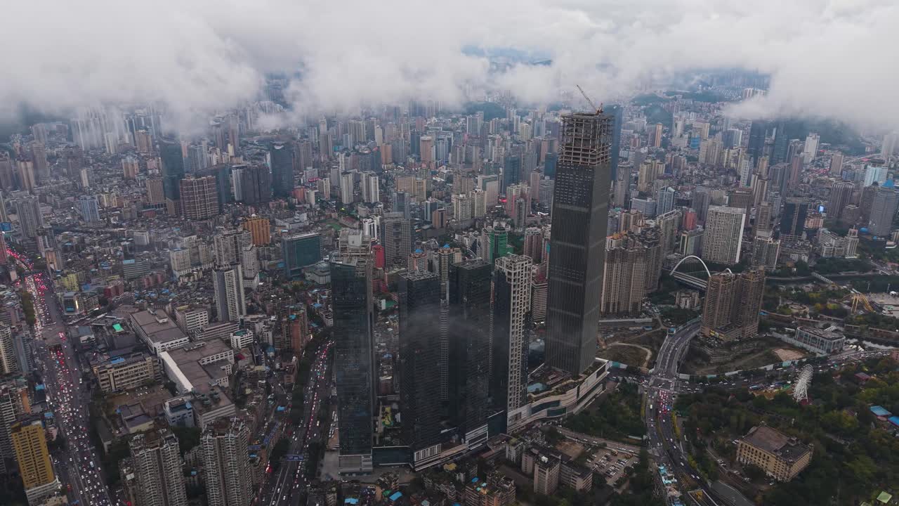 Pull out aerial shot of Guiyang, Guizhou Province, showcasing dense urban neighborhoods, modern skyscrapers, and a sprawling cityscape captured in UHD. China