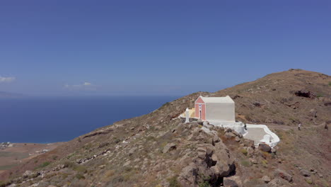 antena: toma en órbita de una pequeña iglesia en una isla griega en la cima de una colina