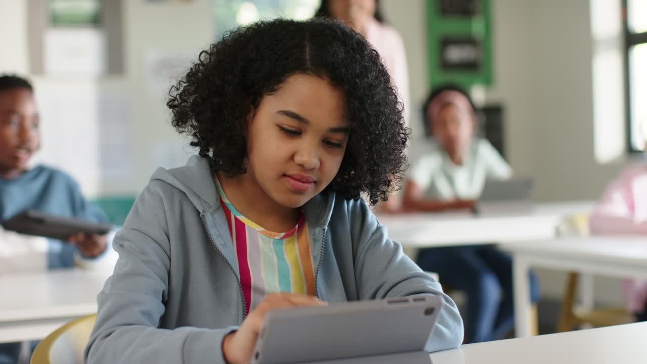 Un'adolescente afroamericana che tocca un tablet alla reception, prima corruga la fronte e poi alza il pugno dopo aver risolto il problema