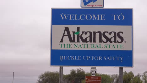 a road sign welcomes visitors to the state of arkansas