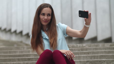 Empresaria-Tomando-Una-Foto-Selfie-En-Un-Teléfono-Inteligente.-Mujer-Haciendo-Pucheros-Con-Los-Labios-Al-Aire-Libre