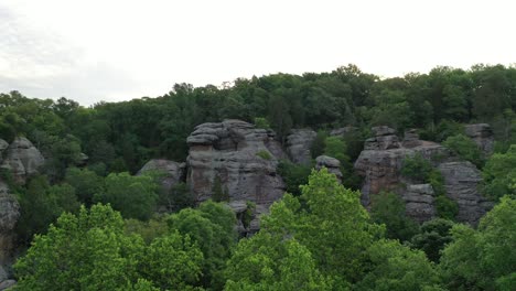 felsige klippe, die in der sommersaison mit dichtem grünen wald bedeckt ist, luftaufnahme