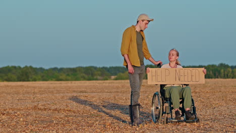person in wheelchair asking for help in field