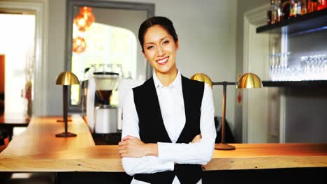 portrait of smiling waitress standing behind the counter