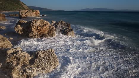 Grandes-Olas-Salpicando-Y-Haciendo-Espuma-En-Los-Acantilados-Sumergidos-En-La-Playa,-Espectacular-Escena-Marina-En-La-Costa-Del-Mediterráneo