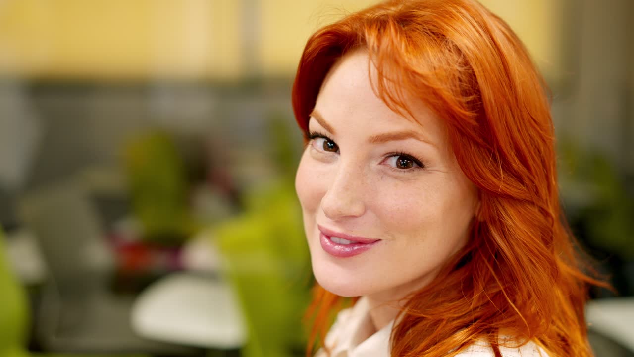Beauty woman smiling at camera sitting in a coworking