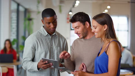 multi-cultural business team with digital tablets meeting in modern open plan office