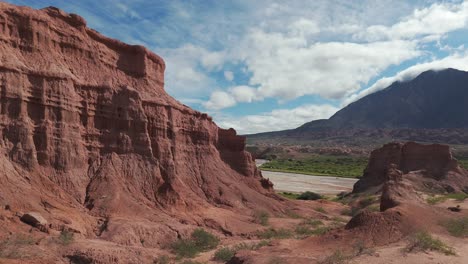 Formaciones-Rocosas-Rojas-Y-Exuberante-Vegetación-En-La-Ruta-68,-Quebrada-De-Las-Conchas,-Salta-Bajo-Un-Cielo-Azul-Brillante