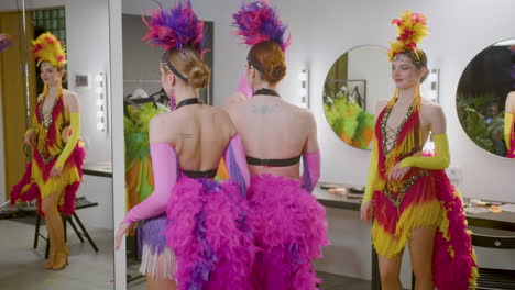 tres chicas en vestidos de cabaret divirtiéndose antes de comenzar el espectáculo