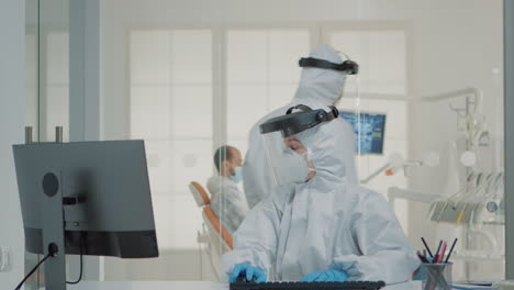 dentistry team of specialists with ppe suits using computer