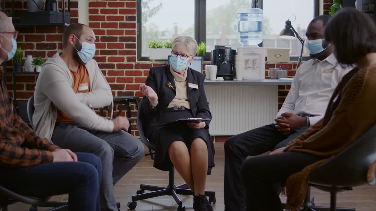 Counselor helping people with alcohol addiction at aa meeting therapy during covid 19 pandemic