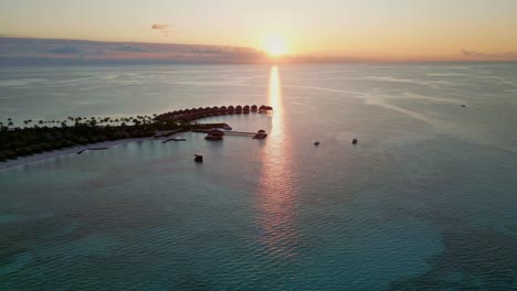 aerial view approaching a pier and holiday homes, sunny evening in the maldives