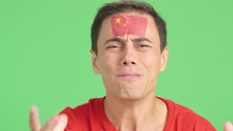 very nervous man supporting chinese team during a difficult match