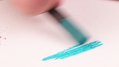 drawing with a light blue crayon on a piece of paper