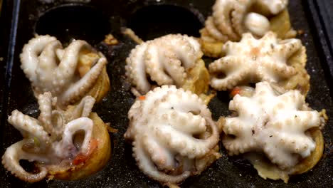 cooking ball-shaped on street food dumpling fried snack dish with big squid at japan. japanese name for this food "takoyaki". 4k uhd