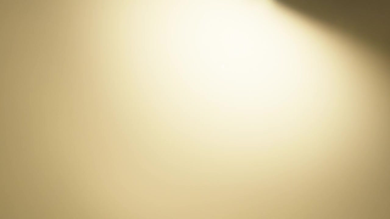 Yellow lens flare overlay fading out to black background in slow motion