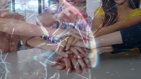 Light-trails-over-a-globe-against-diverse-office-colleagues-staking-their-hands-together-at-office