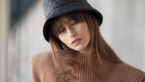 close-up-portrait-of-a-beautiful-girl-in-a-black-panama-hat-hugging-a-leather-bag