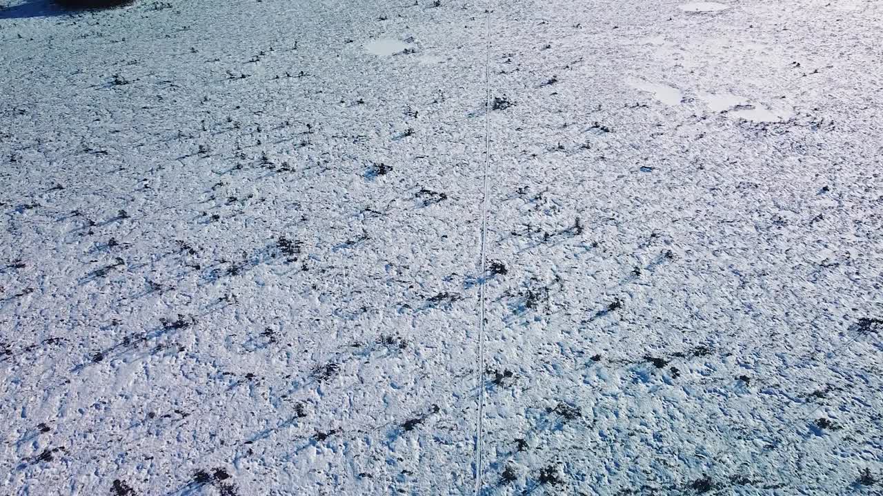화창한 겨울날 등산로와 얼어붙은 호수가 있는 눈 덮인 늪지 풍경의 공중 조감도, 두니카 이탄 습지, 높은 고도 광각 드론 샷이 뒤로 이동