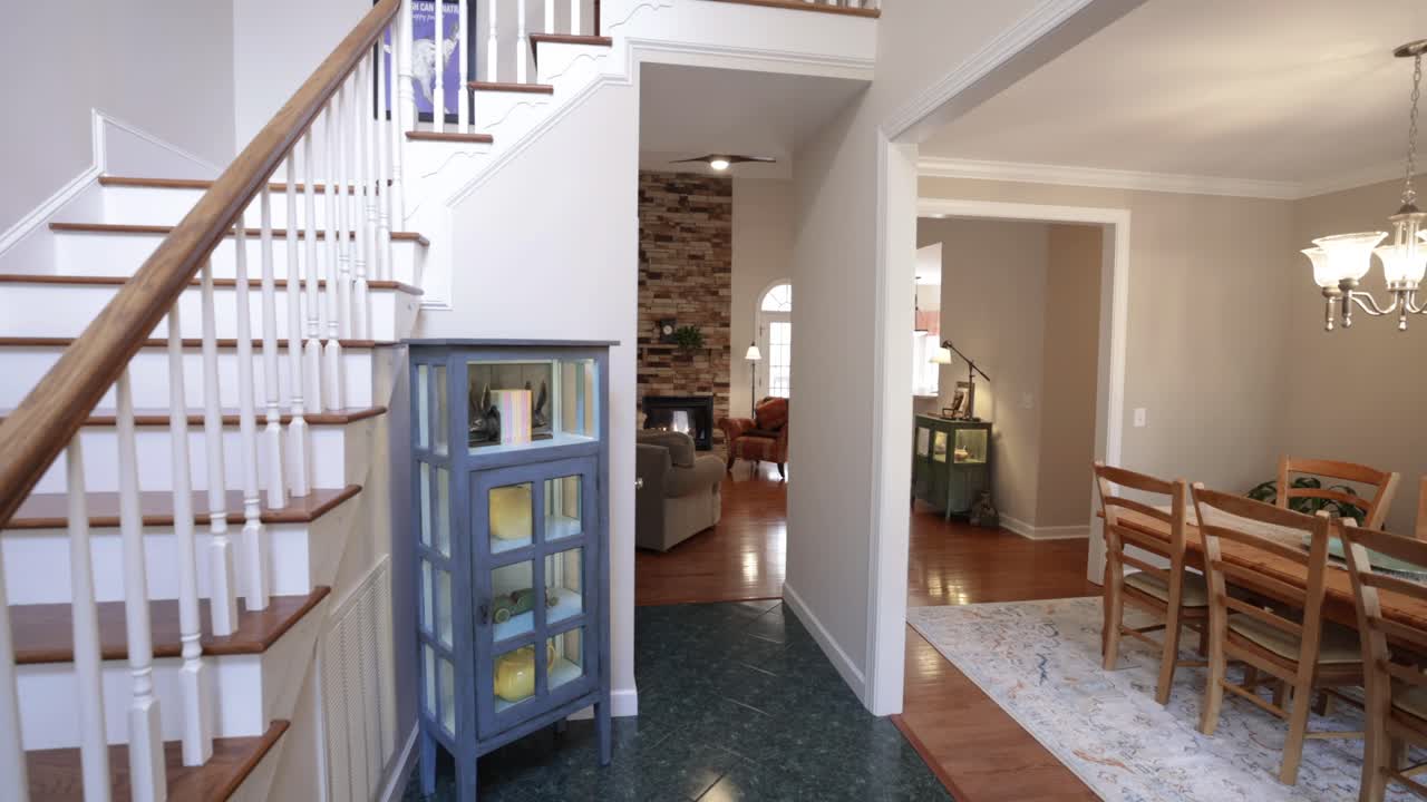 식당, 계단, 거실이 있는 고급스러운 집으로 들어가는