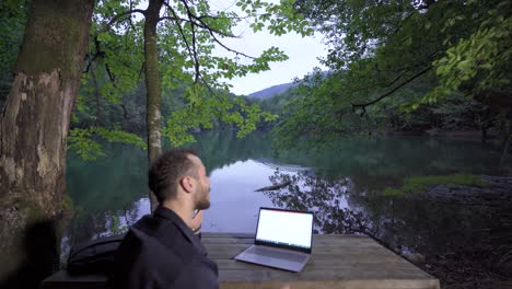 businessman working against lake view.