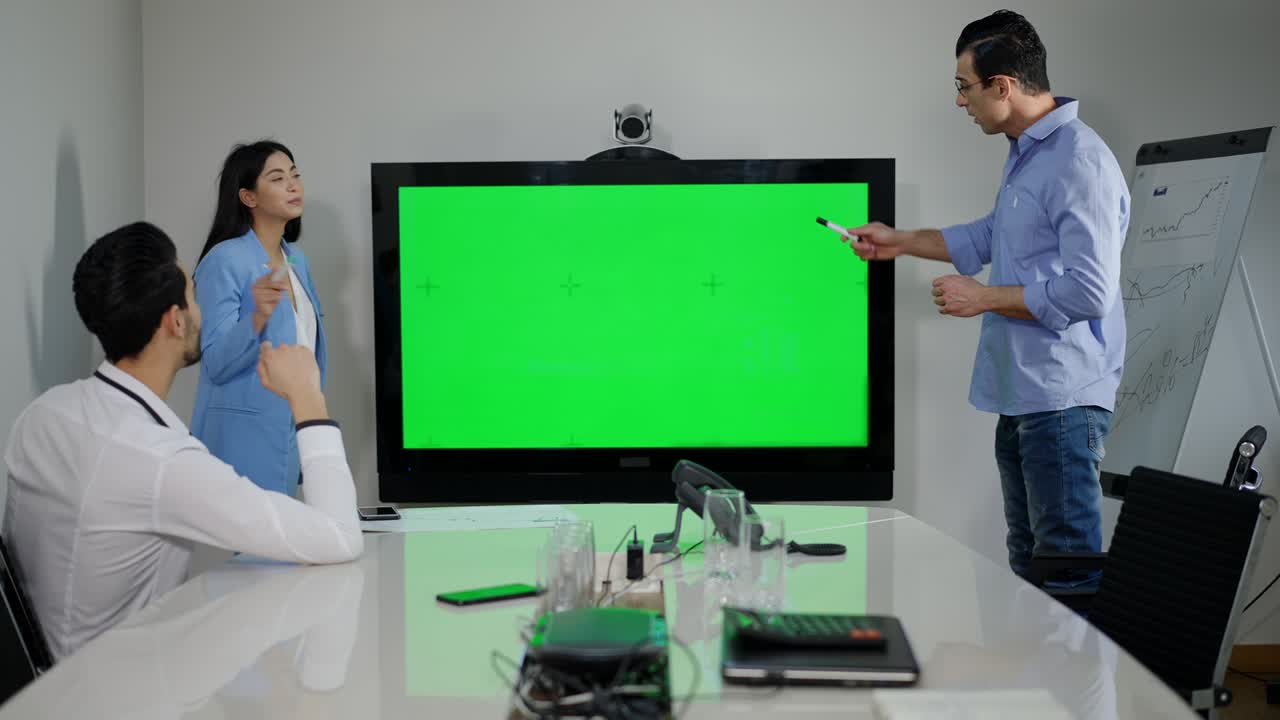 자신감 넘치는 밀레니얼 다민족 동료들이 녹색 화면 모니터와 함께 사무실에서 프로젝트를 논의합니다. 집중된 아시아 여성과 중동 남성이 크롬케이 화면으로 실내에서 브레인 스토밍을합니다.